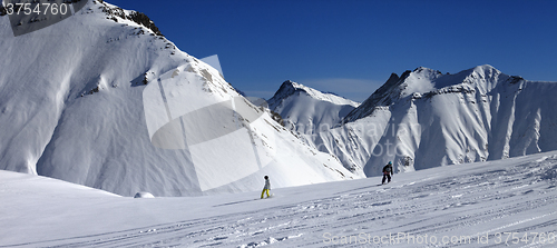 Image of Panoramic view of snowboarders downhill on off piste slope after