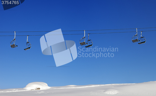 Image of Chair-lift and blue clear sky at sun day