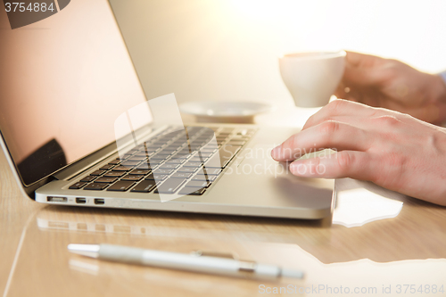 Image of The hand on the keyboard and coffee