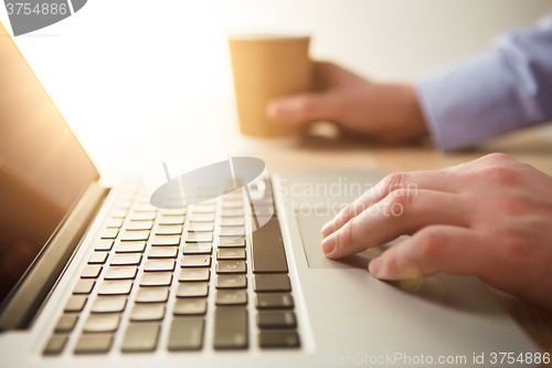 Image of The hand on the keyboard and coffee