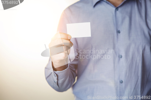 Image of Man holding white business card 