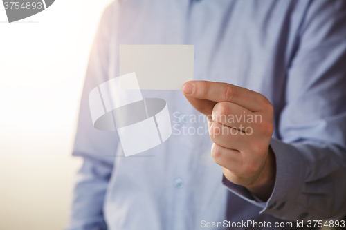 Image of Man holding white business card 