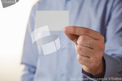 Image of Man holding white business card 