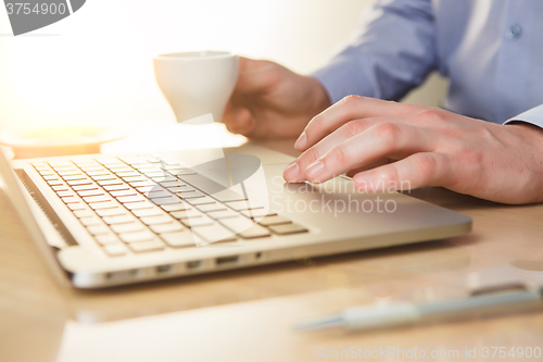 Image of The hand on the keyboard and coffee
