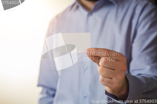 Image of Man holding white business card 