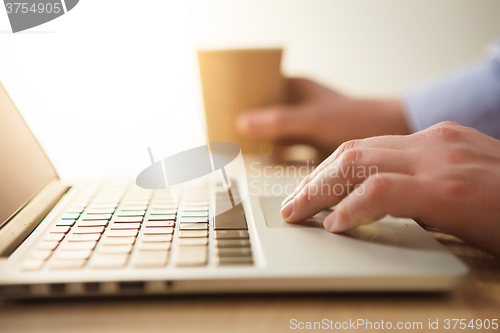 Image of The hand on the keyboard and coffee