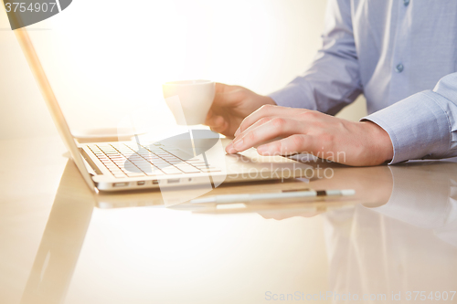 Image of The hand on the keyboard and coffee