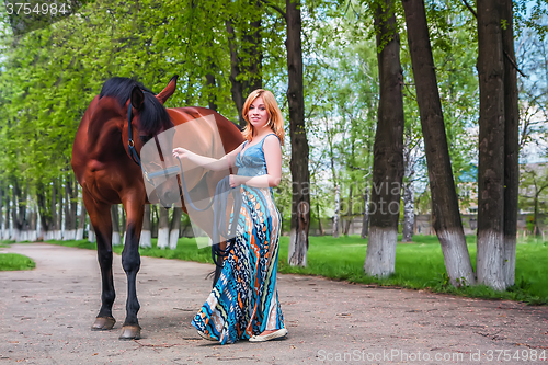 Image of Young blond with a beautiful horse