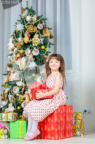 Image of Happy little girl with christmas present smiling
