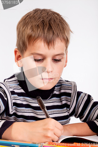 Image of Cute schoolboy is writting