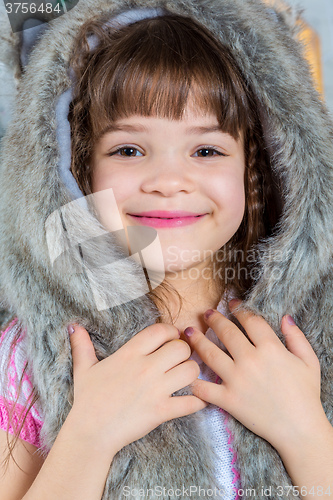 Image of Cute little happy girl posing in a fur hat.