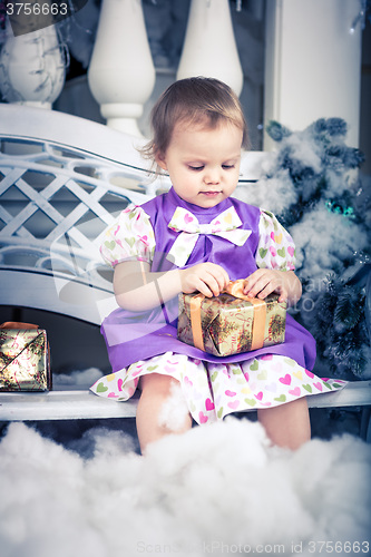 Image of baby girl with christmas present