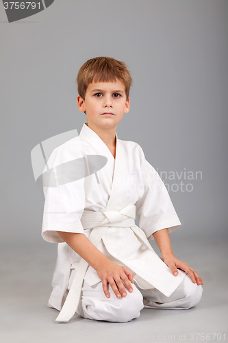 Image of Karate boy in white kimono is sitting