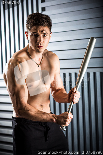 Image of muscular man posing with a bat