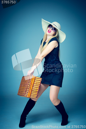 Image of The traveler woman standing with retro suitcase 