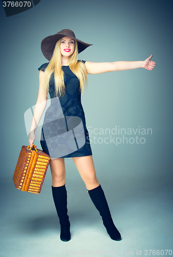 Image of The traveler woman standing with retro suitcase