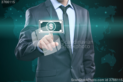 Image of Businessman presses digital interface dollar sign 