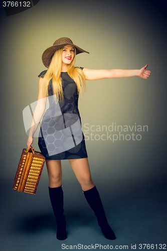 Image of The traveler woman standing with retro suitcase 