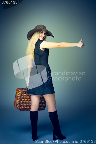 Image of The traveler woman standing with retro suitcase