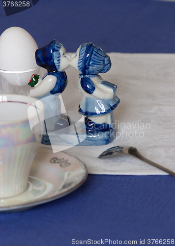 Image of Pretty porcelain figurine on a table laid for an early breakfast