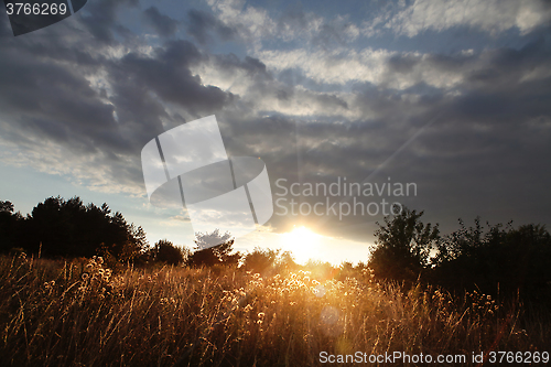 Image of sunset with clouds over field