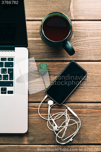 Image of Workplace with open laptop on modern wooden desk 