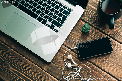 Image of Workplace with open laptop on modern wooden desk 