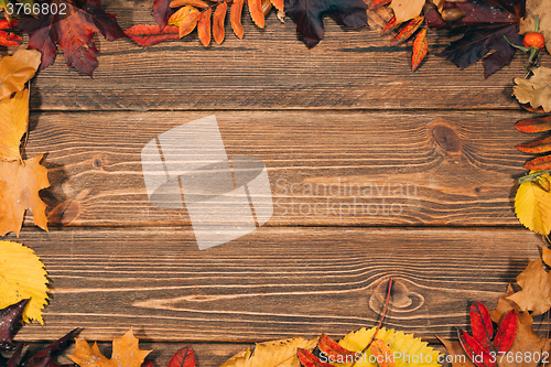 Image of Background with wooden table and autumnal leaves