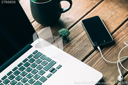 Image of Workplace with open laptop on modern wooden desk 