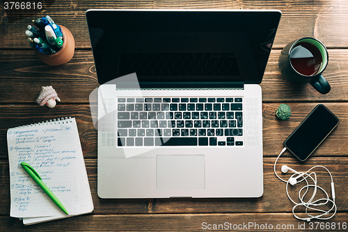 Image of Workplace with open laptop on modern wooden desk 