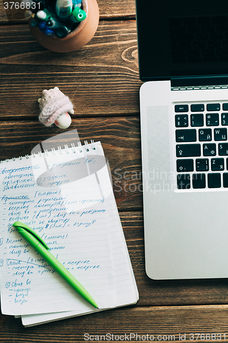 Image of Workplace with open laptop on modern wooden desk 