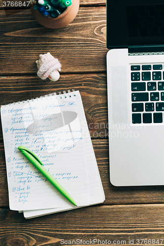 Image of Workplace with open laptop on modern wooden desk 