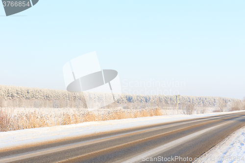 Image of Winter road through snowy fields and forests