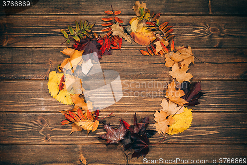 Image of Background with wooden table and autumnal leaves