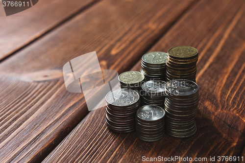 Image of Top view coins on old wooden desk with copy space on top.