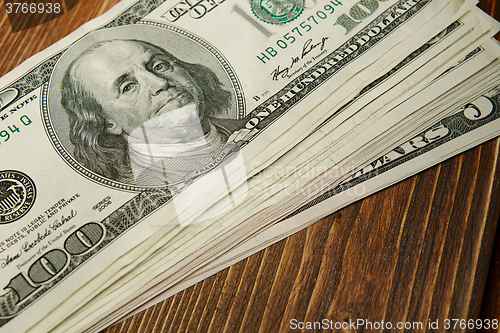 Image of Bundle of money on wooden background