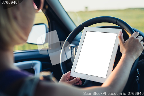 Image of Woman using tablet pc in the car