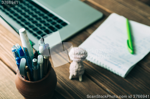 Image of Workplace with open laptop on modern wooden desk 