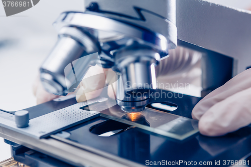 Image of Scientist hands with microscope