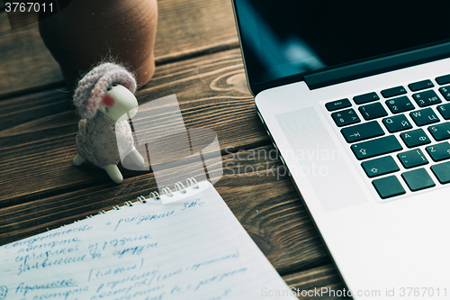 Image of Workplace with open laptop on modern wooden desk 