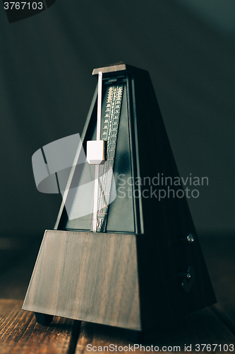 Image of Vintage metronome, on a dark background.