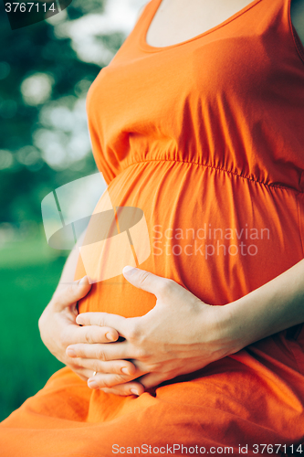 Image of Pregnant woman, holding in hands bouquet of daisy 