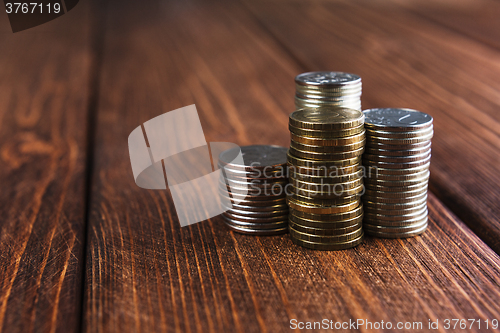 Image of Top view coins on old wooden desk with copy space on top.