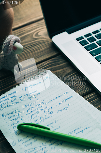 Image of Workplace with open laptop on modern wooden desk 