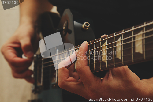 Image of Man playing on guitar