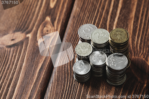 Image of Top view coins on old wooden desk with copy space on top.