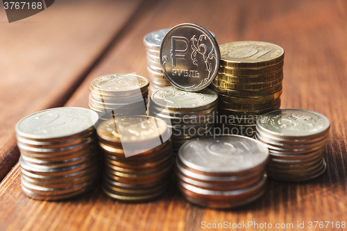 Image of Top view coins on old wooden desk with copy space on top.