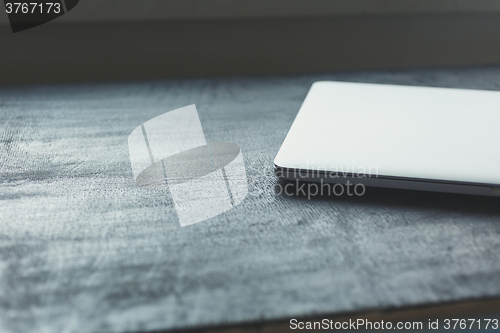 Image of Closed aptop on modern wooden desk 