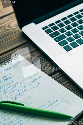 Image of Workplace with open laptop on modern wooden desk 