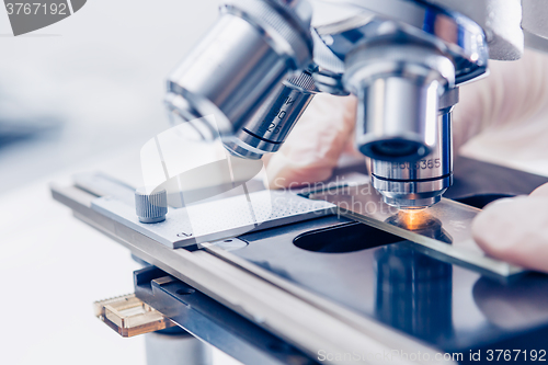 Image of Scientist hands with microscope